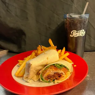 a burrito and fries on a red plate