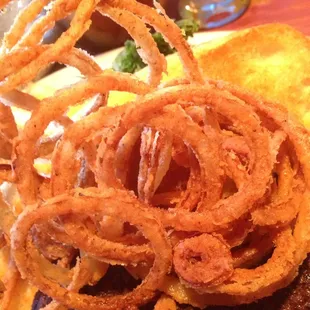 a burger with onion rings on it
