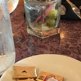 a glass of water and a plate of snacks