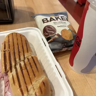 Cuban sandwich, chips, and a fountain drink.