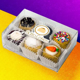 a variety of cupcakes in a clear box