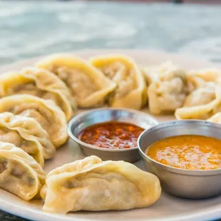 a plate of dumplings with dipping sauce