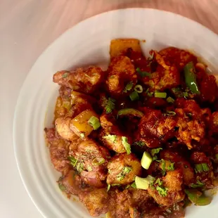Cauliflower Manchurian:(Crunchy yet juicy cauliflower florets coated in mouthwatering sauces &
tossed with sesame seeds & green onions.)