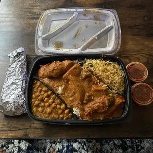 Channa Masala (side) , Chicken Tikka Masala over a bed of pulao, Vegetable Biryani (side), Naan, and Vindaloo sauce on the side.