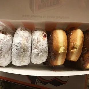 A half dozen powdered jelly and chocolate covered Boston creme doughnuts