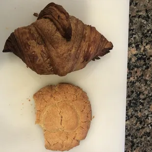 Croissant and partially consumed peanut butter cookie