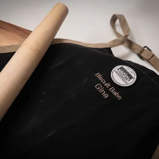 a black apron with a wooden handle