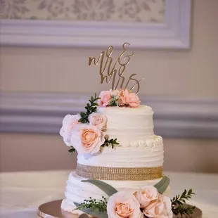 3tiered banana flavored wedding cake. They made this for us &amp; over 300 slices of sheet cake with a rose on top for our guests.