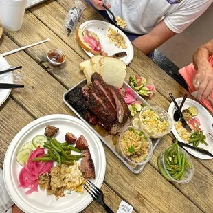 a man and woman sitting at a table with plates of food