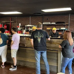 Andrew "Butter" Soto (yellow hat on the right) is on the front lines serving generous portions of his amazing barbecue!