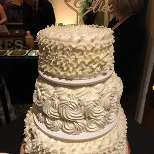 Top and bottom layer is up ruffled design and middle is rosettes in buttercream!