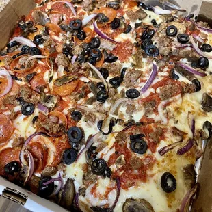 Custom Buttercrust pie with sausage, red onions, black olives, mushrooms, and half pepperoni cups