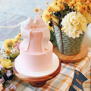 a pink cake with a bow on top