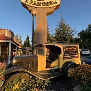 an old truck parked in front of a sign