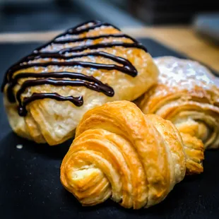 three pastries on a black plate