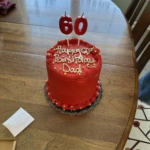 Red birthday cake with gold lettering saying &quot;happy 60th birthday dad&quot;