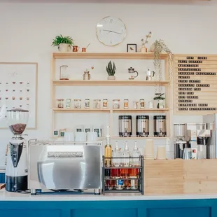 a counter with a coffee machine and shelves