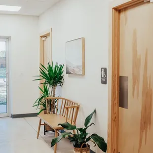 a hallway with a bench and potted plants