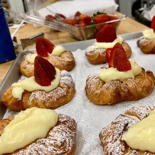a tray of pastries with cream and strawberries