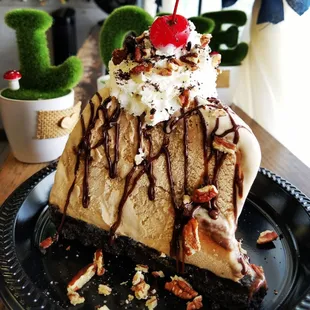 Kona Coffee Ice Cream Mud Pie on an Oreo Crust topped with whipped cream, hot fudge, pecans, and maraschino cherry .. limited time special