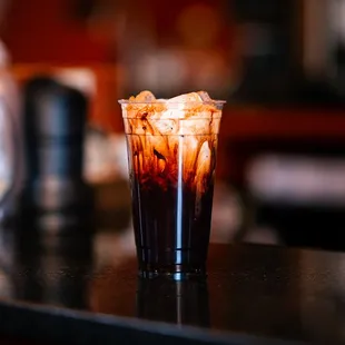 a glass of iced coffee on a counter
