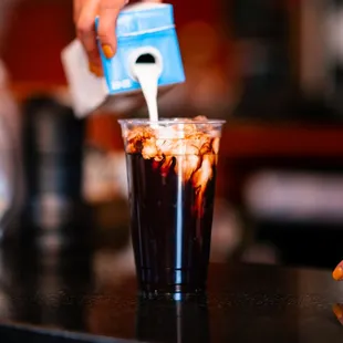 a person pouring coffee into a cup