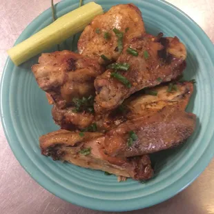 a plate of chicken wings and a pickle