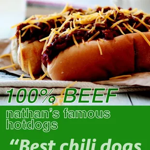 two chili dogs with cheese on them