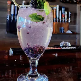 a glass of blueberry mojit
