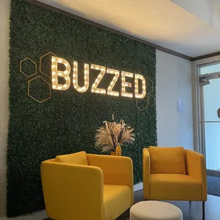 two yellow chairs in front of a green wall