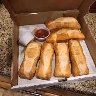 a box of breadsticks and dipping sauce