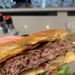 a hand holding a hamburger