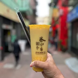 a hand holding a cup of boba tea