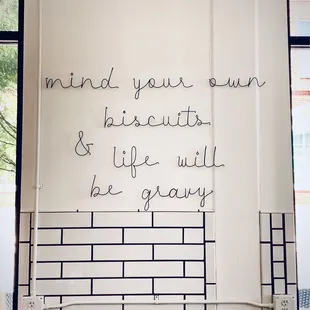 a sign that reads mind your own, his city, and life will be gray