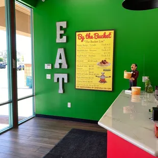 a green wall with a sign that says eat