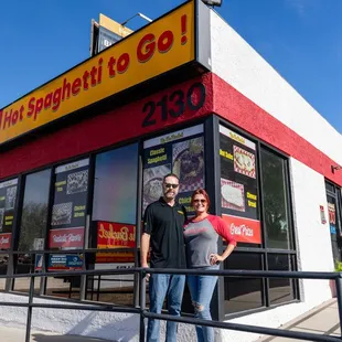 a man and a woman standing in front of a fast food restaurant