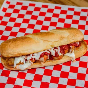 a hot dog on a red and white checkered paper