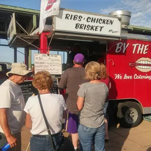 a group of people standing in front of a food truck