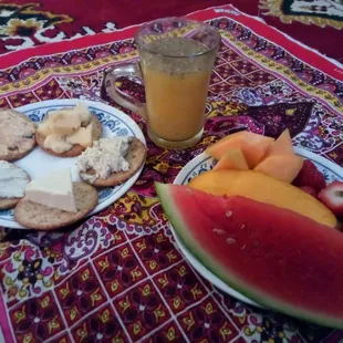 Vegetable crackers and beverage. Three cheeses and two spreads. Fruits from papaya to strawberry.