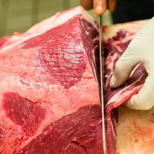 a person cutting a piece of meat
