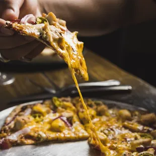 a person holding a slice of pizza