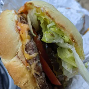 a cheeseburger with lettuce and tomato