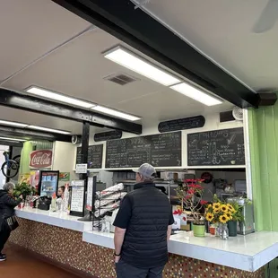 a man standing at a counter in a restaurant