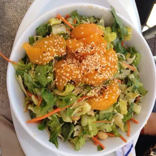 a bowl of salad with oranges and lettuce