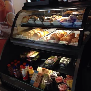 a display case filled with pastries and condiments