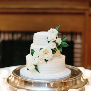 a white wedding cake on a silver platter