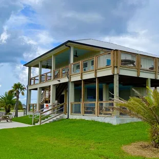 a beach house with a deck overlooking the water