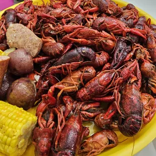 a plate of craws, potatoes, corn, and potatoes