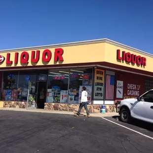 a man walking in front of a liquor store