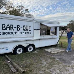 shows a man standing in front of a food truck